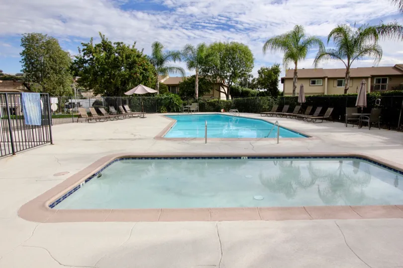 Nice swimming pools on a sunny day in between villas with palm trees in Lake Glen Park of La Mesa