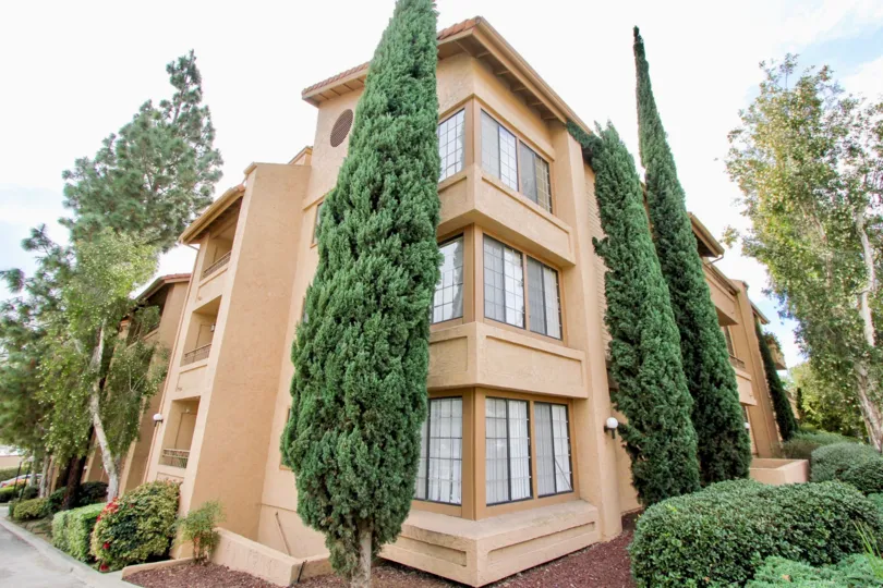 a view of an orange building in Lake Park Way Terrace in a sunny day with some huge trees in front