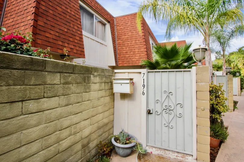 THE 7196 APARTMENT IN THE MELODY LANE CONDOS WITH THE FLOWER PLANT, TREES, STEEL GATE