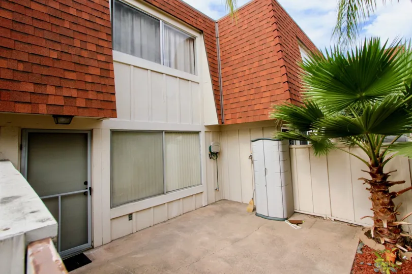 Two story condo with a red roof & palm tree at Melody Lane Condos in La Mesa CA