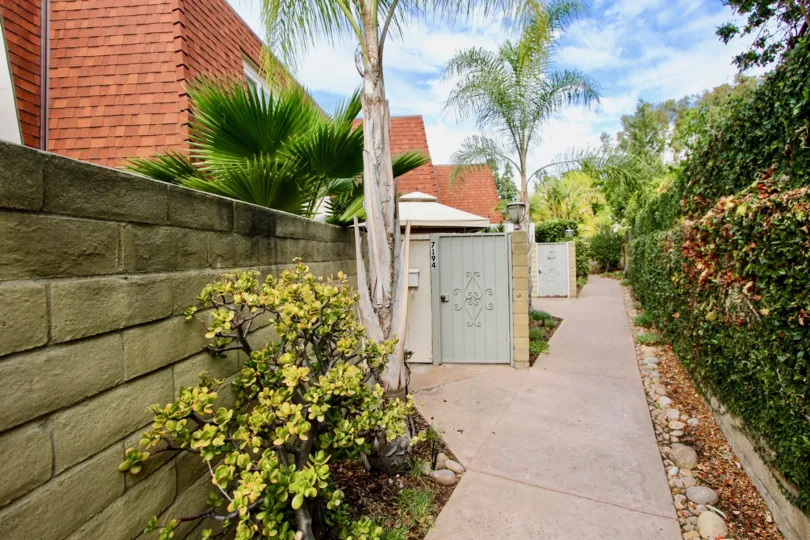 THE HOUSE IN THE MELODY LANE CONDOS WITH THE TREES, PLANTS, PATHWAY