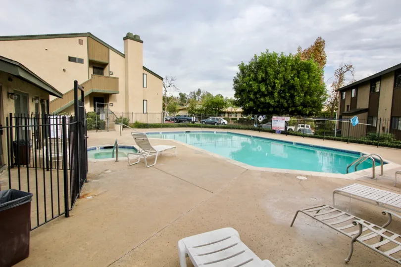 Private fenced in swimming pool for residents with adjacent soaking pool and deckside chairs in La Mesa
