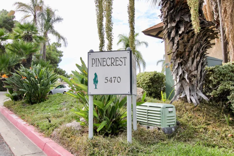 The Pinecrest entrance with a name board and lots of small plants around