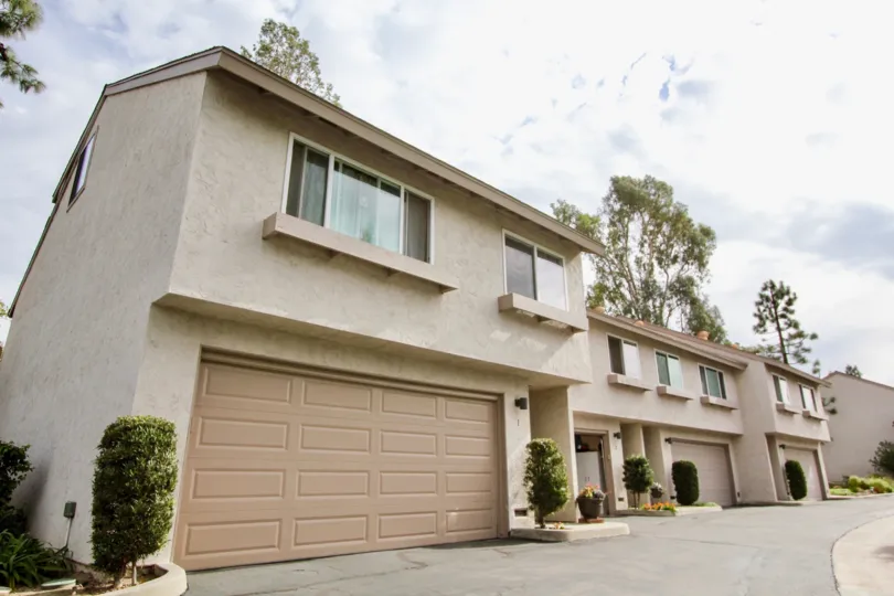 A sunny day in the Pinecrest with a apartment and vehicles.