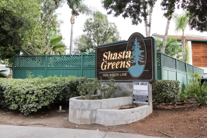 A signage with green wooden fencing in the Shasta Greens neighborhood.