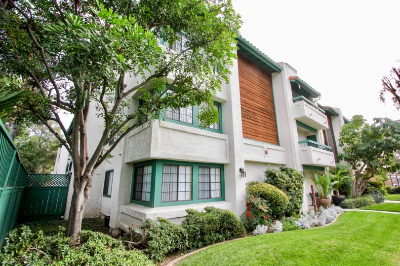 THE APARTMENT IN THE SHASTA GREENS WITH THE LAWN, TREES, STEEL WALL, BALCONIS, FLOWER PLANTS
