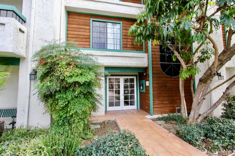 A low-rise townhouse with wooden cladding and green trimmings in the Shasta Greens community.