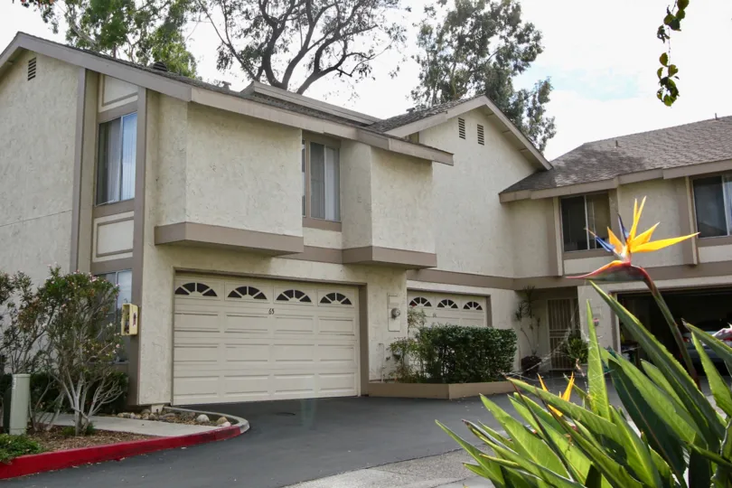 A two story condominium complex with a green hedge at La Mesa CA in Strawberry HIlls