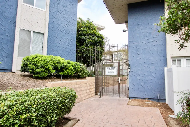 A black iron security gate next to a blue wall at Villa De Sur in La Mesa CA