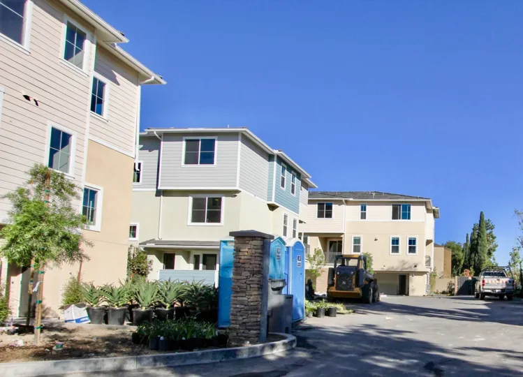 A sunny day in the area of Aura, outside, condos, porta pottys, trees, windows