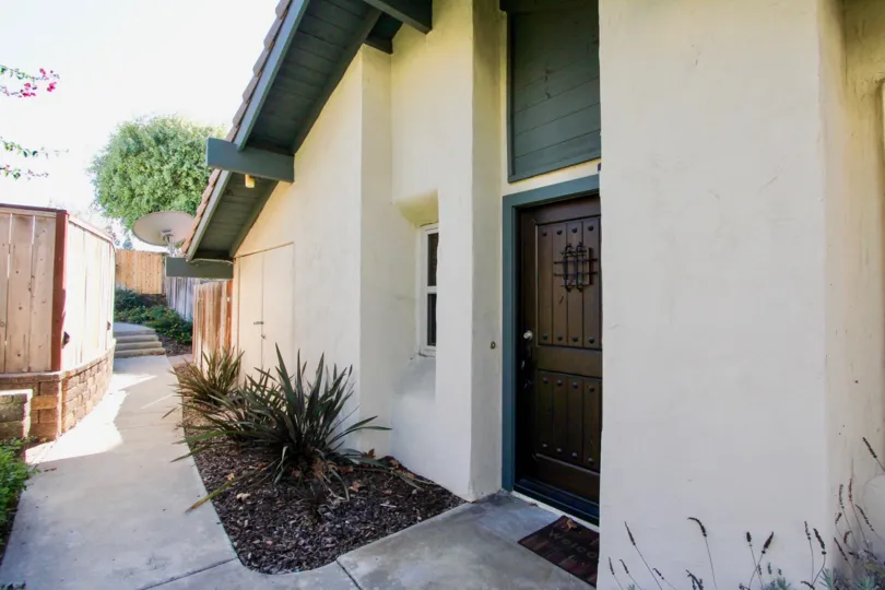 A sunny day in the area of Black Mountain Villas, outside, f=doormat, bushes, wooden fence, condos