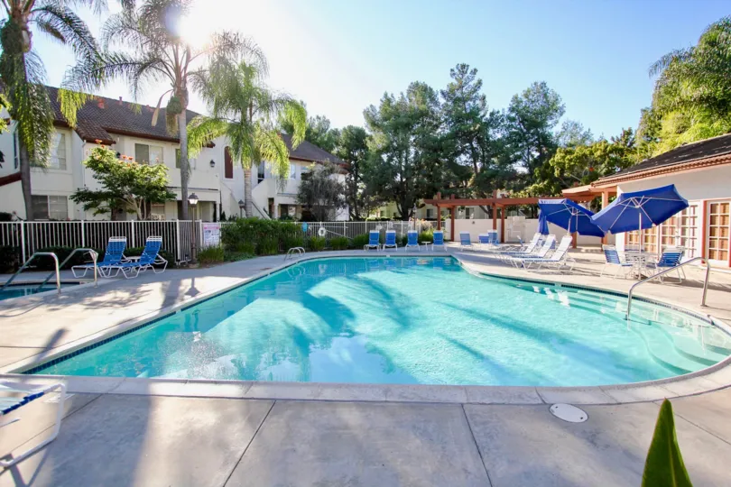 A beautiful swimming pool in the Canyon Bluffs with some chairs and covered with iron grill.