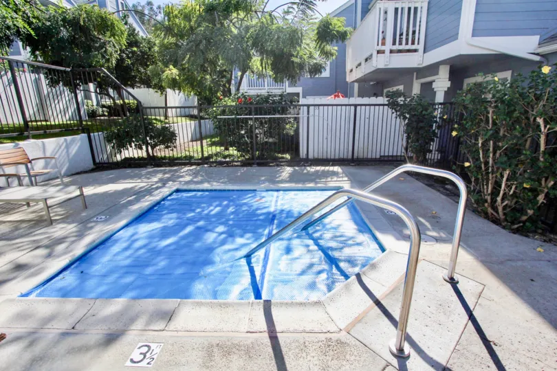 THE BUILDING IN THE CANYON COLONY WITH THE SWIMMING POOL, TABLES, ROSE PLANTS, TREES, BALCONI