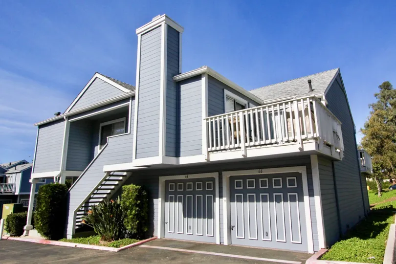 A two story blue home with white trim & chimney in Mira Mesa CA at Canyon Colony