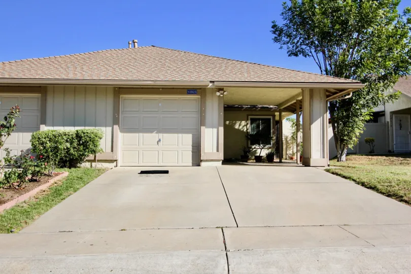 house with a pretty basic design and plenty of space, a garage and plants on each side