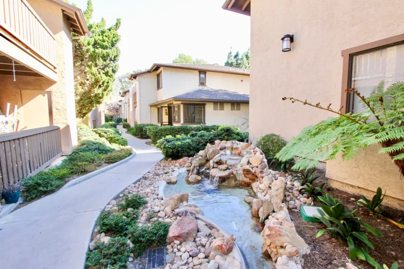 Beautiful artificial water stream in between villas with green trees in Quail Creek of Mira Mesa