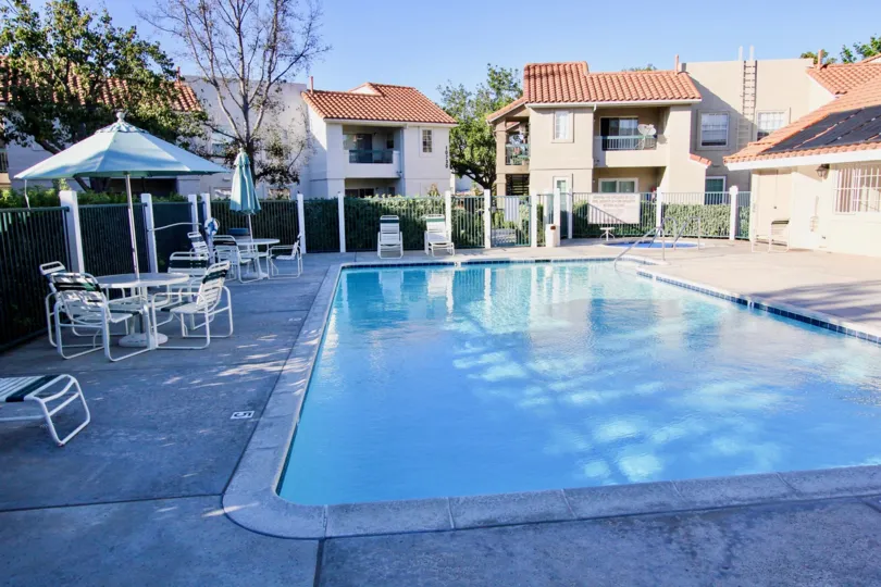 This beautiful swimming pool is located in the community of Summit Ridge, which have the lot of the chairs and tables and infront of beautiful houses, trees are there