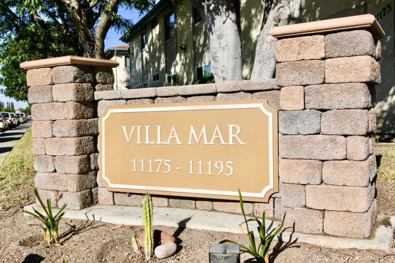 A stone signage of the Villa Mar community painted in beige color.