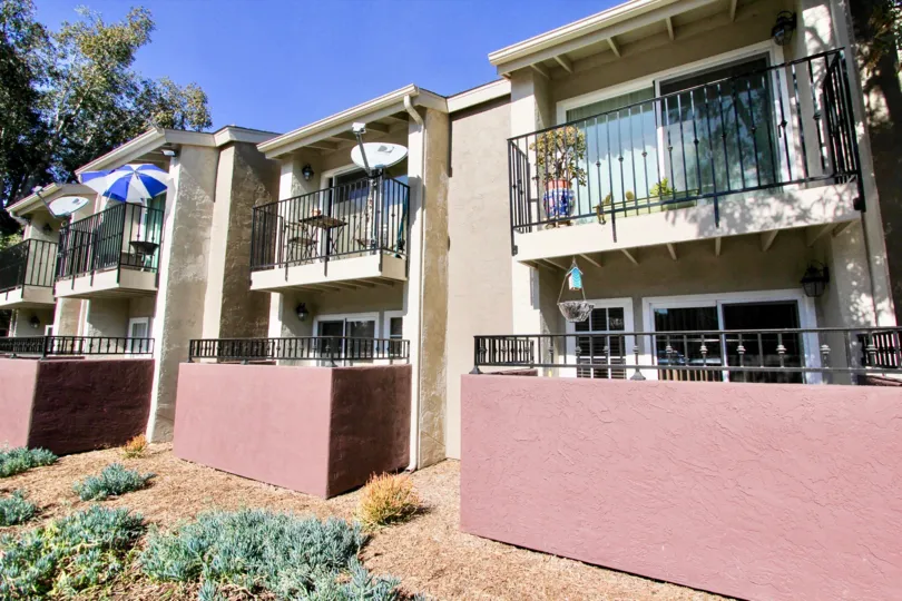 A residential building with pink walls around it's patios at Windsor Park in Mira Mesa CA