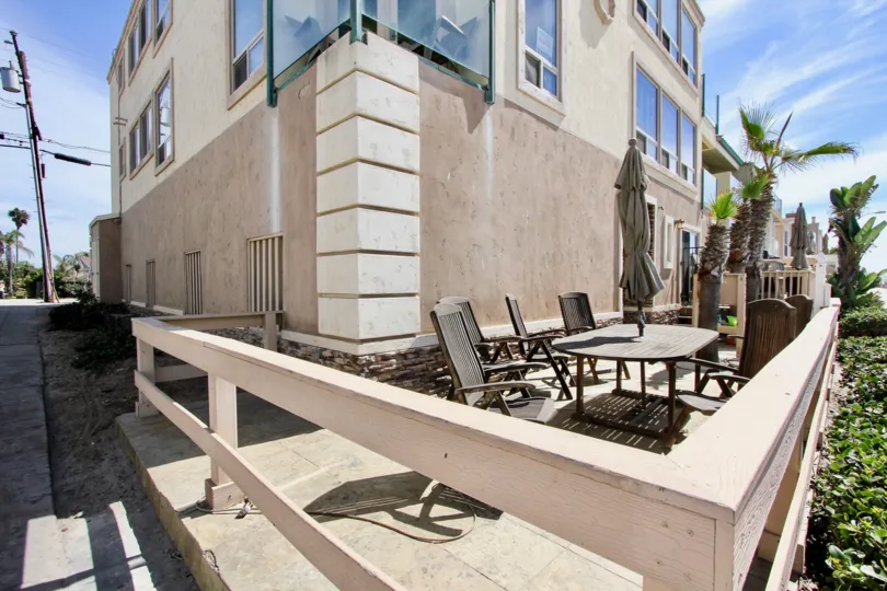 A beautiful patio set-up with table, chairs, and umbrella at 3243 Ocean Front Walk in Mission Beach, CA