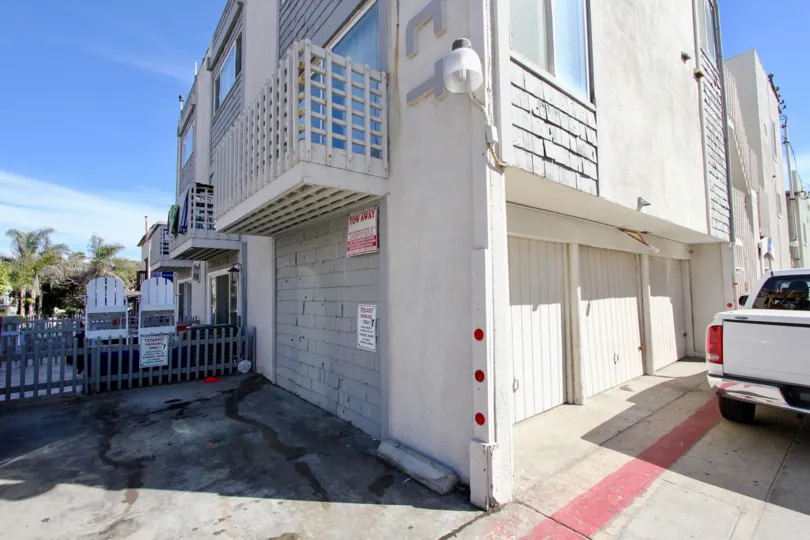 White apartment building with garages and available parking