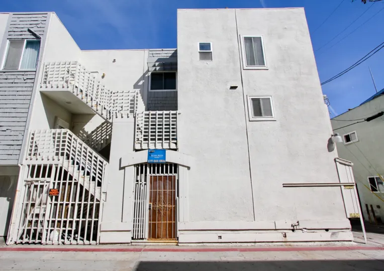 A white gate guards an enclosed utility area at 711 Island Court