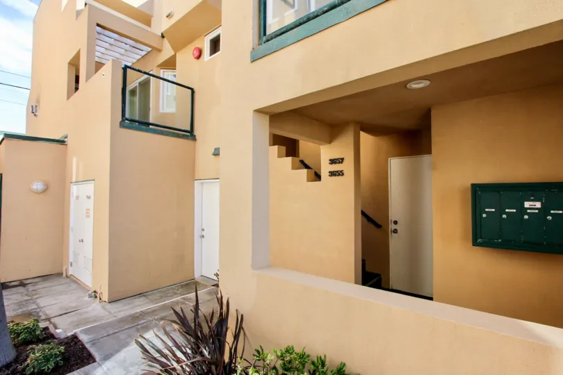 Brown building with green mail boxes and white doors in Mission Beach CA at Far Horizon