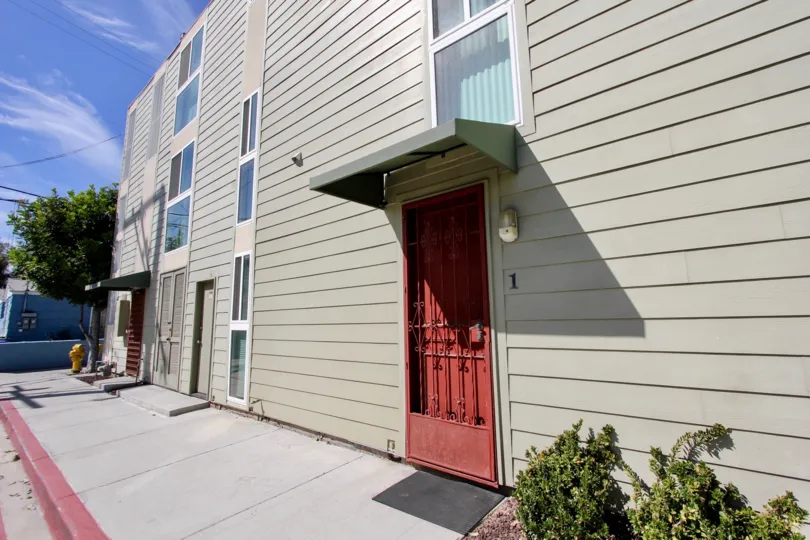 Bright red security door on a gray building at Franklin Shores in Mission Beach CA