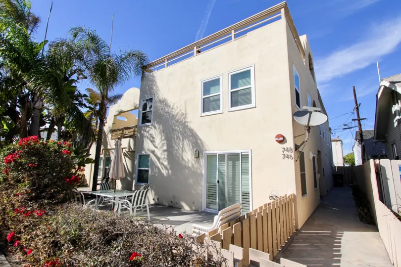 A view of ther rear outdoor patio dining area at the white stucco Isthmus Condos.