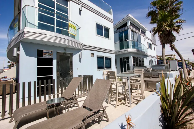 A sunny, bright day at the Jamaica Sands with facilities for lounging, relaxing and barbecuing, and dotted with palm trees.