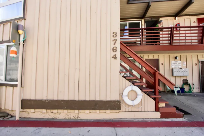 A hotel in the Mission Beach Bayside with an old women watching outside.