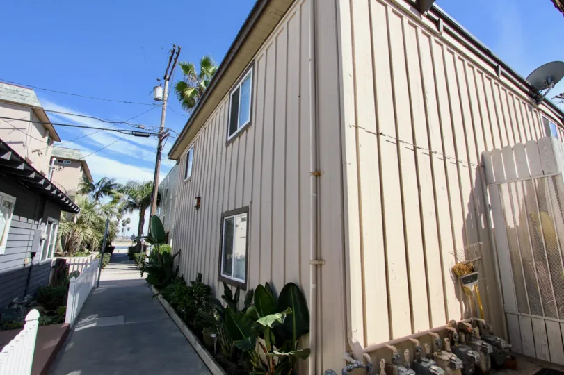A sunny day in the area of Mission Beach Bayside, sidewalk, plants, windows, condos
