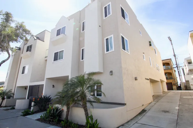 A street view of an adobe property with plenty of windows on a clear day in Mission Beach Villas