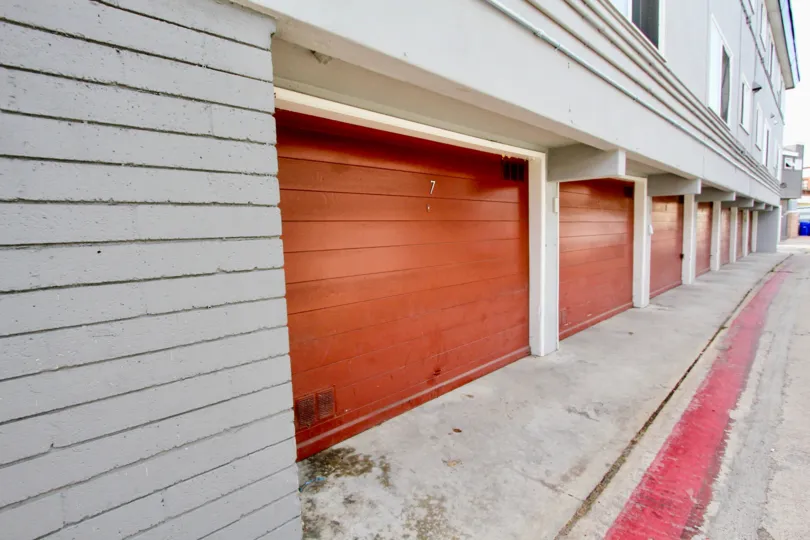 A red line runs along the ground in front of garages at Mission View Point
