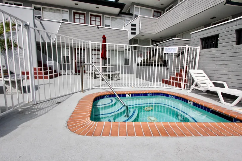 A single white lounge chair sits near a hot tub at Mission View Point.