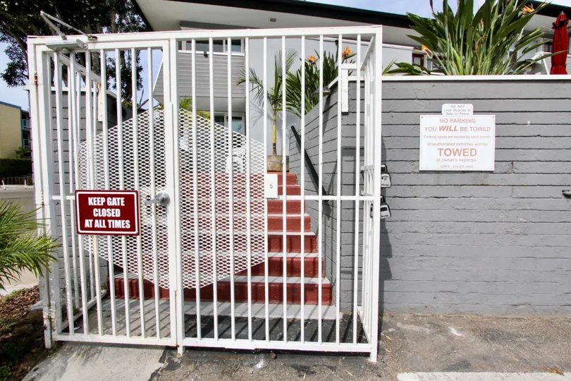 Red sign on the front of a white gate in Mission Beach CA at Mission View Point
