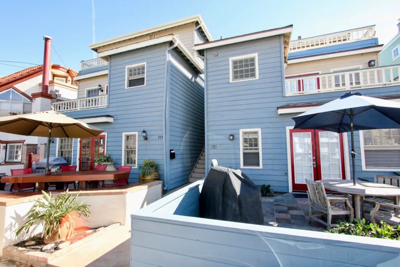 Blue beach house front with red door frames in Mission Beach.