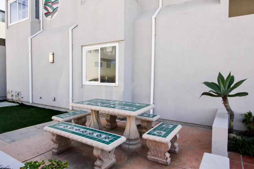 A tiled patio set with deck and palm trees at Ocean Front One