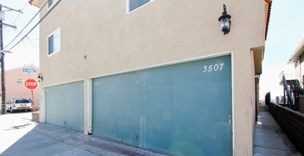Two blue garage doors next to a stop sign inside the Ocean Front Villas in Mission Beach CA