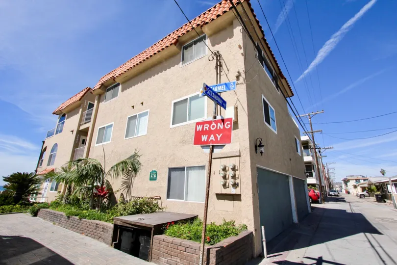 A SUNNY DAY IN THE OCEAN FRONT VILLAS WITH WRONG WAY BOARD, CAR PARKING.