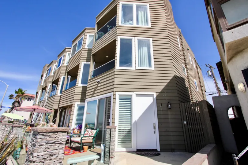 An umbrella and colorful chairs sit on a patio at Ocean West condos