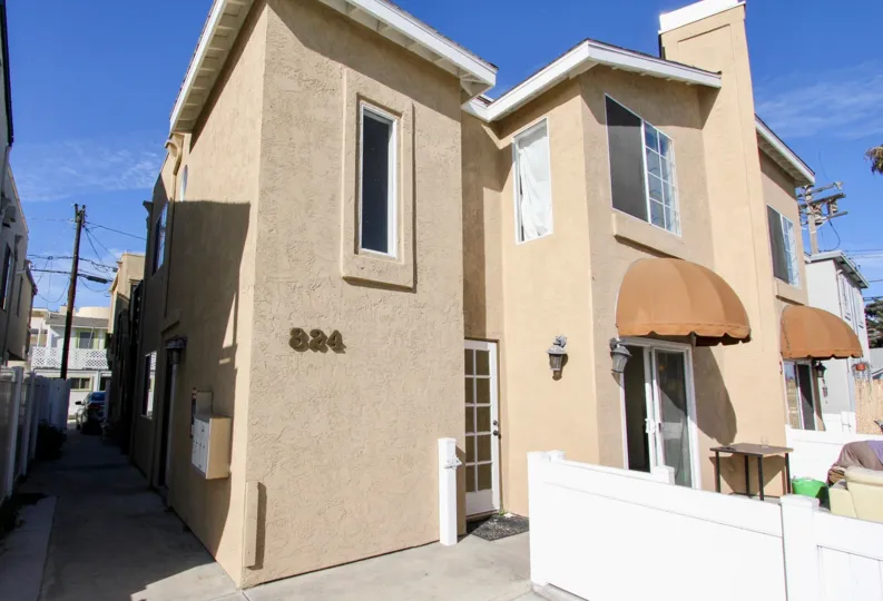 A clear, sunny afteernoon in the Seaburst community with large windows and a stucco exterior.
