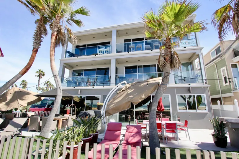 Sunny day outside apartments with palm trees and patio furniture