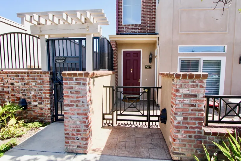 View of house with little walls and metallic front doors in the Cambridge Square