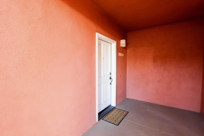 A door is covered the wall painted by red color and numbered the house as 2120