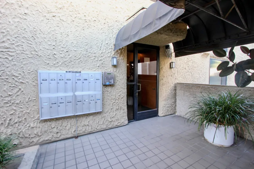 A gray awning covers te entrance to he Cresthill Plaza residential building.