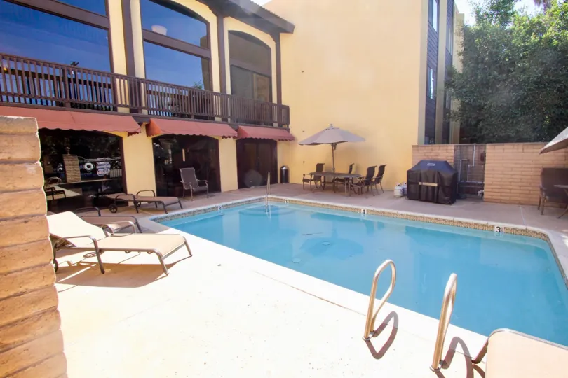 VERY BEAUTIFUL HOUSE. IN FRONT OF IT THERE ARE FOUR SMALL TREES. AND THERE IS A ROAD, VERY CLEAN. AND THERE IS A POOL.