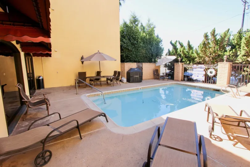 A sunny day poolside in the area of Eagle Canyon, beach chairs, umbrella, grill