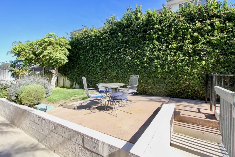 A SUNNY DAY IN THE HARBORVIEW TERRACE WITH THE TABLES, PLANTS, TREES, STEPS
