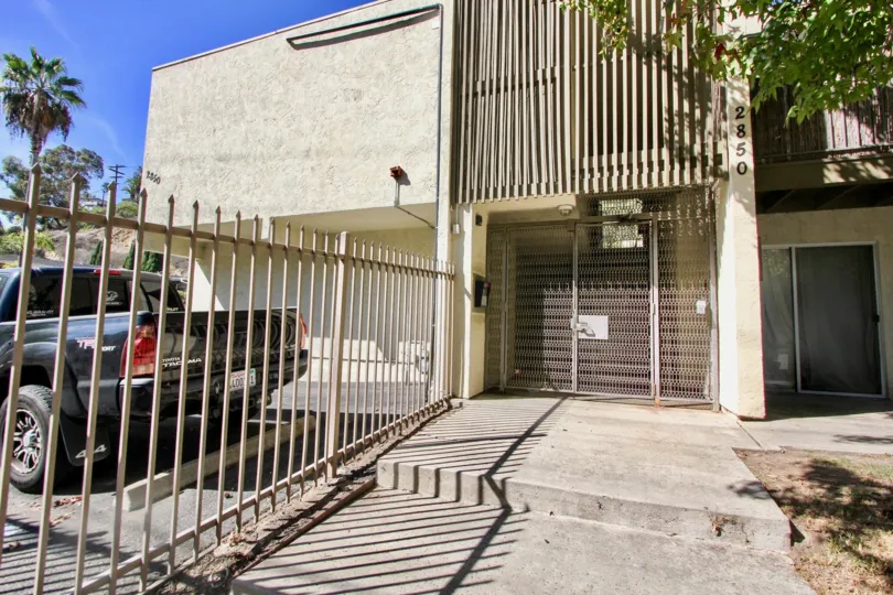 A sunny day in the area of La Casa Reynard, gate, cars, parking lot,